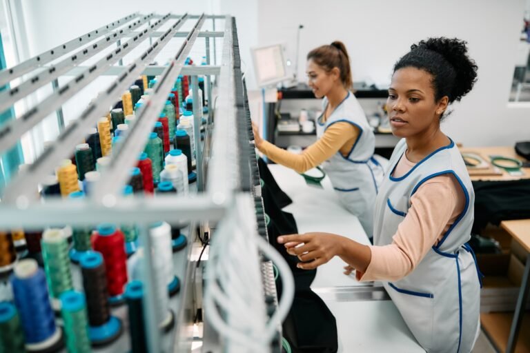 African American seamstress working at embroidery machine in a textile factory.